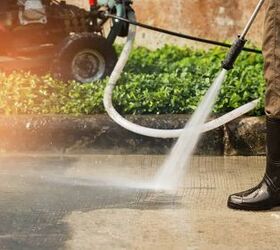 Worker cleaning driveway with gasoline high pressure washer ,professional cleaning services.High pressure deep cleaning.