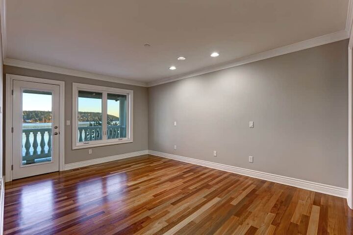 Empty room interior with soft grey walls paint color glossy hardwood floor and door to balcony. Northwest USA